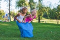 Girls compete in a relay race . Jumping in bags . They laugh and fall . Royalty Free Stock Photo