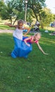 Girls compete in a relay race . Jumping in bags . They laugh and fall . Royalty Free Stock Photo