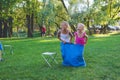 Girls compete in a relay race . Jumping in bags . They laugh and fall . Royalty Free Stock Photo