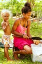 Girls cutting coconut in Lavena village on Taveuni Island, Fiji.