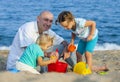 Girls with dad playing at sea Royalty Free Stock Photo