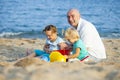 Girls with dad playing on sea shore Royalty Free Stock Photo