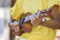 Close up of girl with ukulele in yellow shirt .