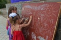 Girls drawing with chalk on a blackboard on Children Protection Day in Volgograd