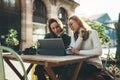 Girls drink coffee relax in cafe outdoor in europe city. Freelancer communicate on project, girls shopping online on wifi tablet Royalty Free Stock Photo