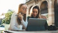 Girls drink coffee relax in cafe outdoor in europe city. Freelancer communicate on project, woman shopping online. Working busines Royalty Free Stock Photo