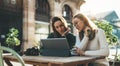 Girls drink coffee relax in cafe outdoor in europe city. Freelancer communicate on project, woman shopping online on wifi tablet Royalty Free Stock Photo