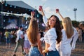 Girls with drinks enjoy live music at sunny beach festival. Group of friends dance, celebrate with cocktails. Summer Royalty Free Stock Photo