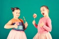 Girls eat big colorful sweet caramels. Children with happy faces