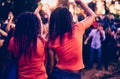 Girls enjoying summer night music party with DJ in outdoor nightclub.