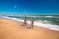 Two positive little girls run along sandy beach Royalty Free Stock Photo