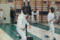 Girls fencers having fencing duel on tournament. Holding a saber