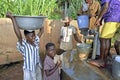 Girls fetch water at a water pump