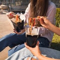 Girls friends chat and share fastfood wok noodles in a street food openair restaurant Royalty Free Stock Photo