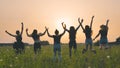 Girls friends are jumping against the background of an evening summer sunset. Royalty Free Stock Photo