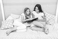 Girls friends or sisters lay bed read book together. Kids prepare go to bed. Pleasant time cozy bedroom. Girls long hair Royalty Free Stock Photo