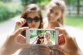 Girls friends taking photos with smartphone outdoors Royalty Free Stock Photo