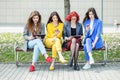 Girls with gadgets are sitting on the bench. The concept of the Internet, social networks, study and lifestyle Royalty Free Stock Photo