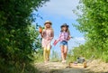 Girls with gardening tools. Sisters helping at farm. On way to family farm. Agriculture concept. Adorable girls in hats