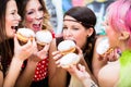 Girls at German Fasching Carnival eating doughnut-like traditional pastry Royalty Free Stock Photo