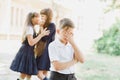 girls gossiping behind the boy s back. Two girls whisper secrets behind a boy. first love Royalty Free Stock Photo