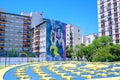 Girls on graffiti and amorial on ground in colors of La Boca Juniors in front of family dwelling in La Boca, Buenos Aires