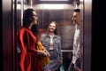 The girls and the guy ride in the elevator. Students in the elevator go to study. People in the elevator. Elevator with people,