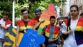 Girls and guys in rainbow vests carry a cardboard figure of a man with the inscription Undo sexism.