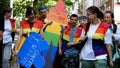 Girls and guys in rainbow vests showing a cardboard figure of a man with the inscription Cancel sexism