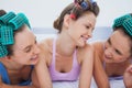 Girls in hair rollers relaxing in bed and talking Royalty Free Stock Photo