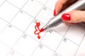 Girls hand with pencil drawing heart shape in calendar for Valentines day Royalty Free Stock Photo