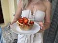 Girls hands hold a basket with ice cream and strawberries