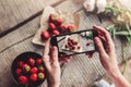 Girls hands taking photo of breakfast with strawberries by smartphone. Royalty Free Stock Photo