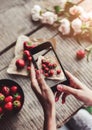 Girls hands taking photo of breakfast with strawberries by smartphone. Royalty Free Stock Photo