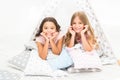 Girls having fun tipi house. Girlish leisure. Sisters share gossips having fun at home. Pajamas party for kids. Cozy Royalty Free Stock Photo