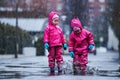 Girls are having fun in water on street in cold autumn day, girls splashing water in rain, cheerful girls enjoying cold weather Royalty Free Stock Photo