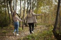 The girls are holding hands. Friends are walking in the autumn forest. Two girls happily walk through the park. Royalty Free Stock Photo