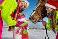 Girls with horse and snowman Royalty Free Stock Photo