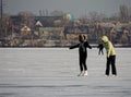 Girls ice skating on the ice of the reservoir along the city embankment