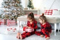 Girls with interest unwrap gifts from Santa on xmas morning