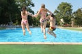 Girls jump in pool Royalty Free Stock Photo