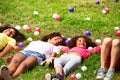 Girls lay in the grass and with color balls around Royalty Free Stock Photo