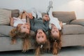 Girls laying down on the sofa upside down and smiling. Group of children is together at home at daytime Royalty Free Stock Photo