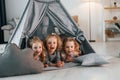 Girls is laying down in the tent. Group of children is together at home at daytime Royalty Free Stock Photo