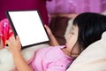 Girls lie down and watch cartoons on tablet on mattress. Child learn by learning online with touch pad.