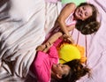 Girls lie on white and pink bed sheets fighting Royalty Free Stock Photo