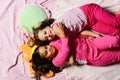 Girls lie on white and pink bed sheets hugging Royalty Free Stock Photo