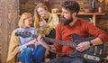 Girls listening to song performed by handsome bearded musician. Guitarist entertaining guests at party. Man with hipster Royalty Free Stock Photo