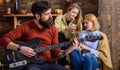 Girls listening to song performed by handsome bearded musician. Guitarist entertaining guests at party. Man with hipster Royalty Free Stock Photo