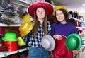 Girls looking for funny hats in store Royalty Free Stock Photo